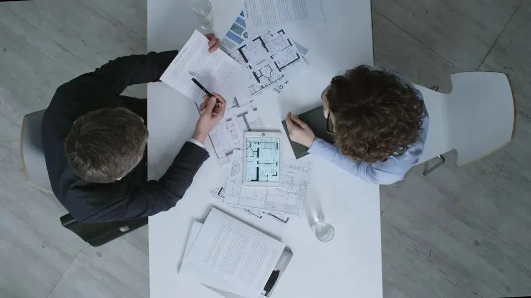 Development professionals reviewing architectural plans and a digital site model